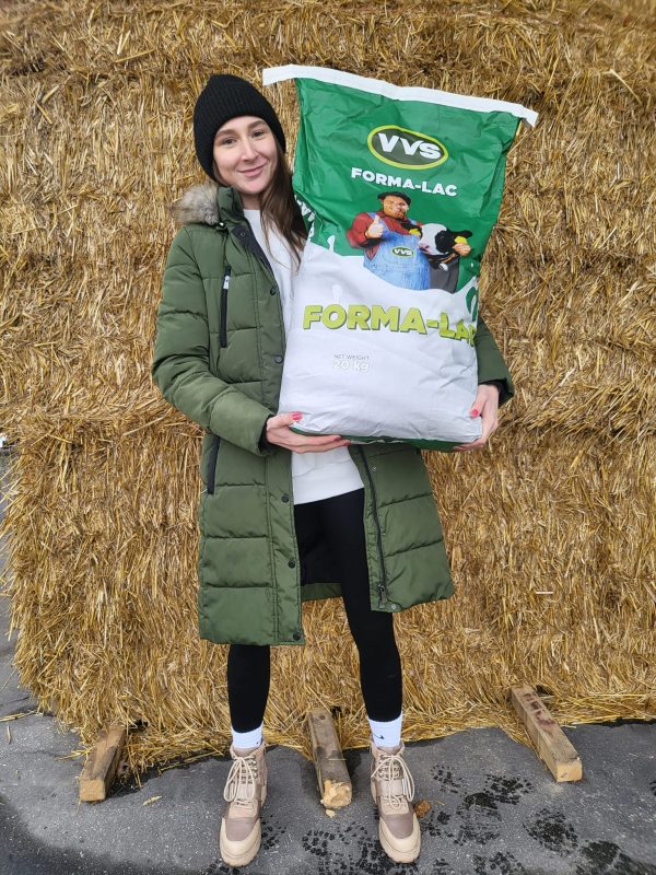 Krmivárska poradkyňa firmy VVS drží v rukách vrece sušeného mlieka pre teľatá Formalac